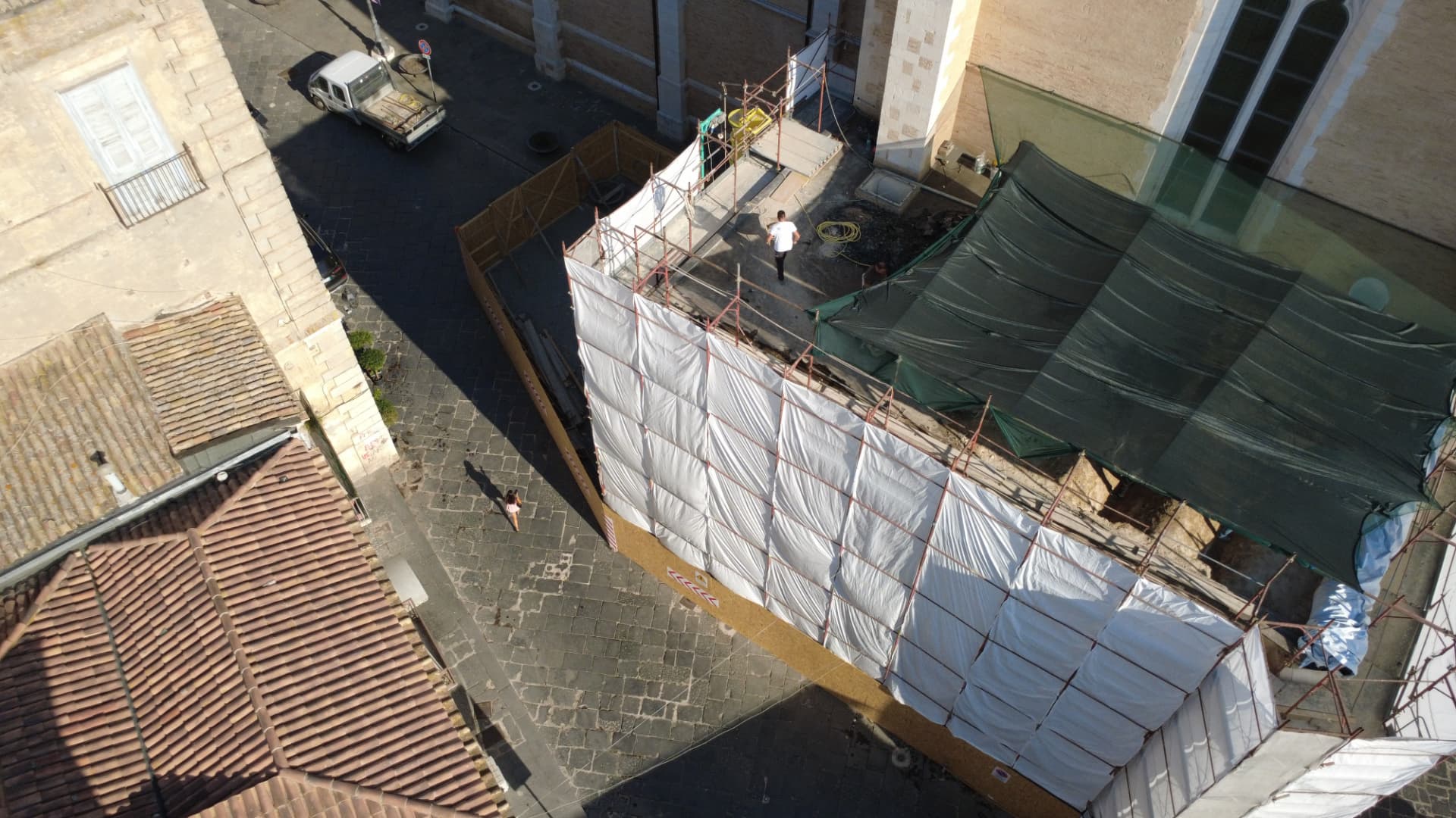 Vista aerea del cantiere: ponteggi e teli di protezione sulla sagrestia